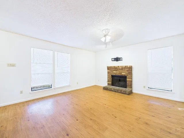 an empty room with a fireplace and windows