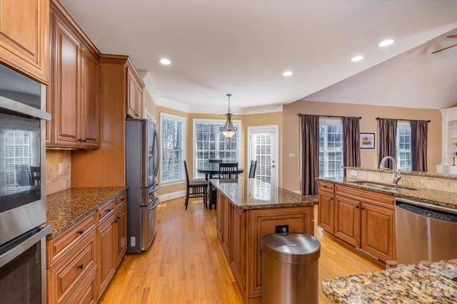 a kitchen with stainless steel appliances granite countertop sink stove top oven and cabinets