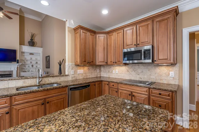 a kitchen with stainless steel appliances granite countertop a sink stove and microwave