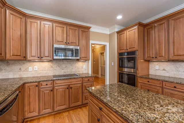 a kitchen with stainless steel appliances granite countertop a refrigerator and stove