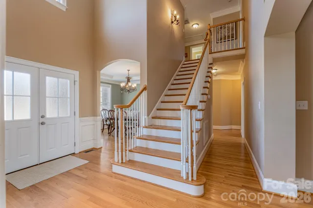 a view of a hallway with wooden floor and stairs