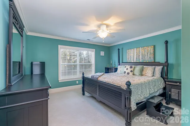 a bedroom with a large bed and a chandelier