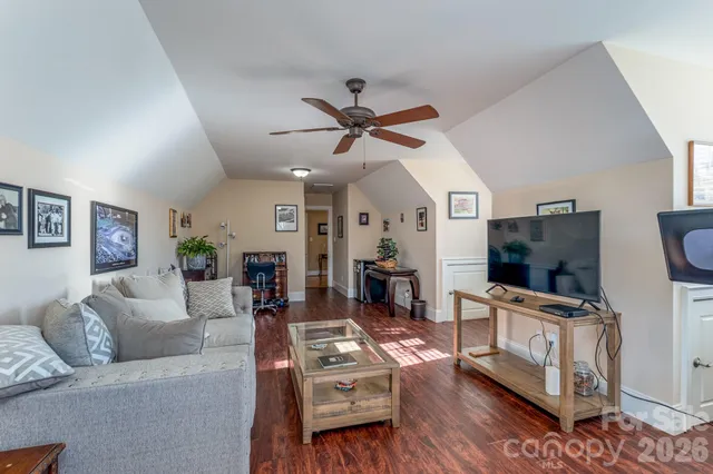 a living room with furniture a flat screen tv and wooden floor