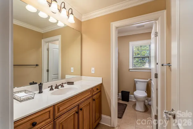 a bathroom with a granite countertop sink a toilet and a mirror