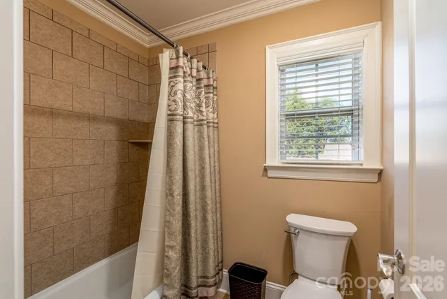 a bathroom with a shower a toilet and sink