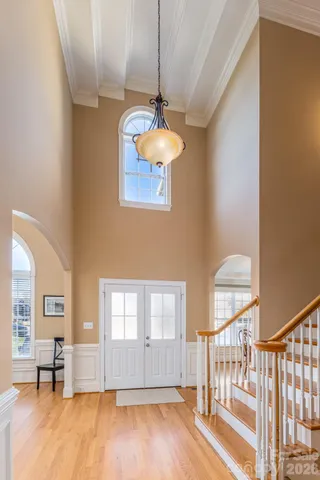 a dining room with wooden floor and a chandelier