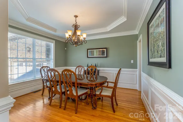 a dining room with furniture a chandelier and wooden floor