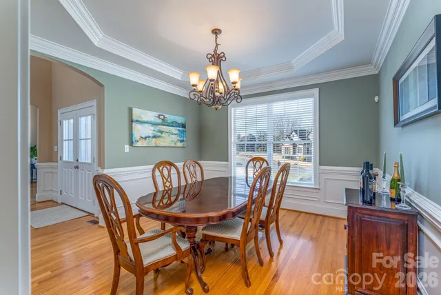 a dining room with furniture a chandelier and wooden floor
