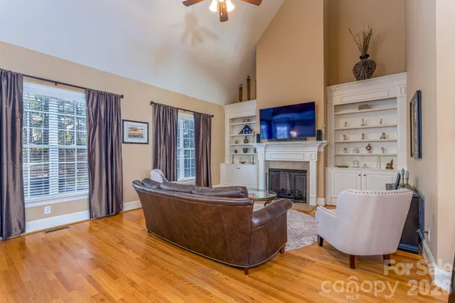 a living room with furniture a fireplace and a large window