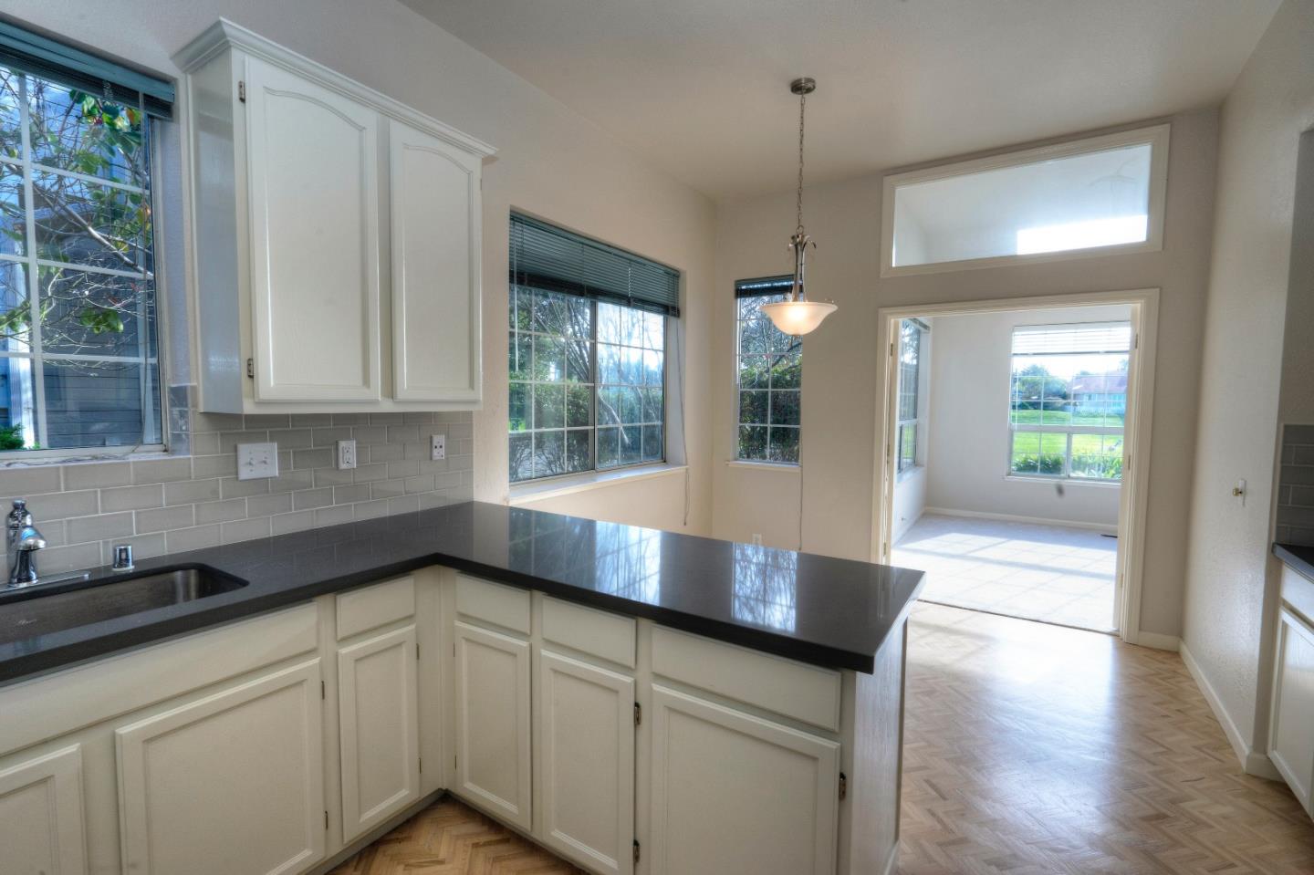 21 Merion Road Half Moon Bay, CA 94019 - Photo 3 of 17 a kitchen with granite countertop white cabinets and a wooden floor