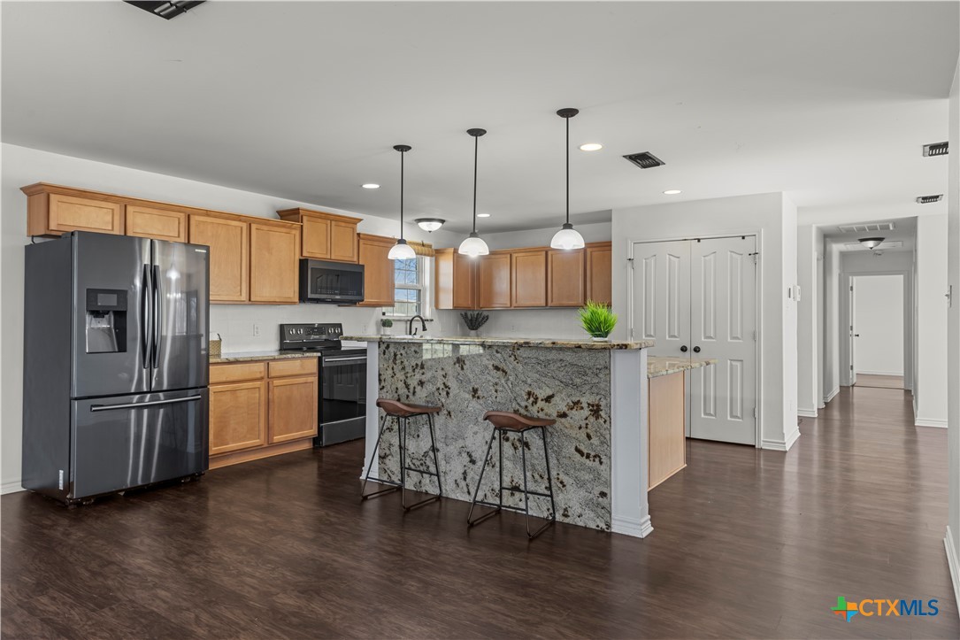 519 Pleasant View Road Troy, TX 76579 - Photo 3 of 33 a kitchen with stainless steel appliances granite countertop a refrigerator a oven a stove and a wooden floors