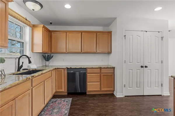 a kitchen with stainless steel appliances granite countertop a sink and cabinets