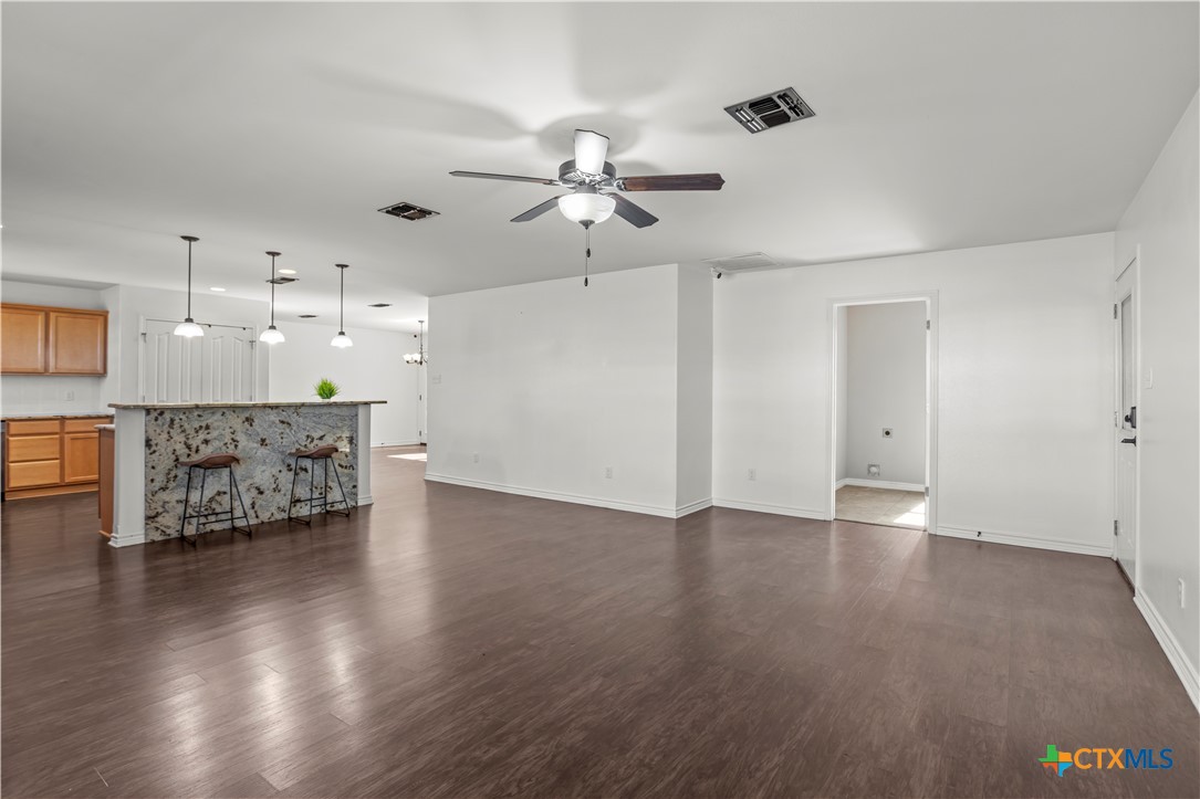 519 Pleasant View Road Troy, TX 76579 - Photo 10 of 33 a view of an empty room with a kitchen and wooden floor
