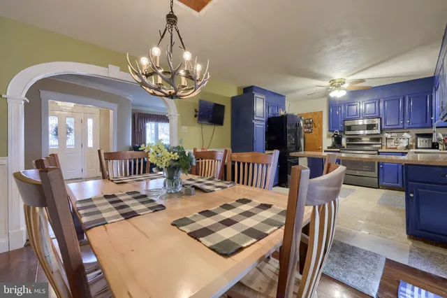 a view of a dining room with furniture a chandelier and wooden floor