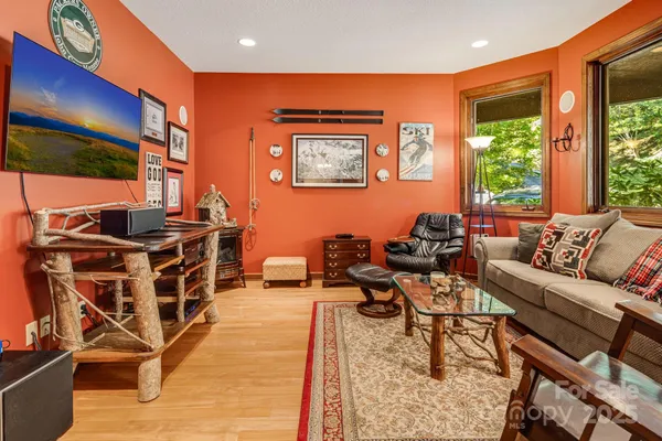 a living room with furniture a flat screen tv and a floor to ceiling window