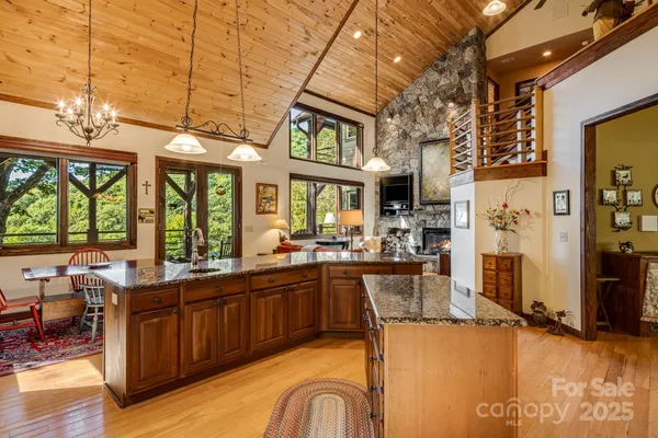 a view of a kitchen with kitchen island granite countertop a large window cabinets and stainless steel appliances