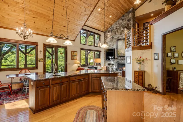 a view of a kitchen with kitchen island granite countertop a large window cabinets and stainless steel appliances