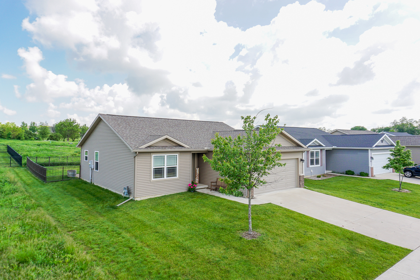 51 Winding Way Bloomington, IL 61705 - Photo 2 of 39 a view of a yard in front of a house with plants and large tree