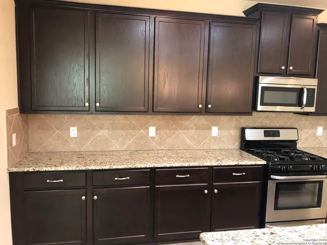 a kitchen with granite countertop cabinets and black appliances
