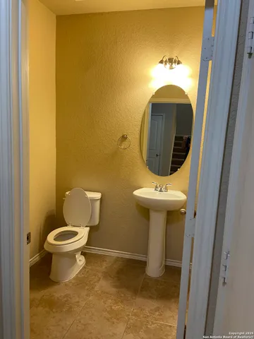 a bathroom with a toilet sink and mirror