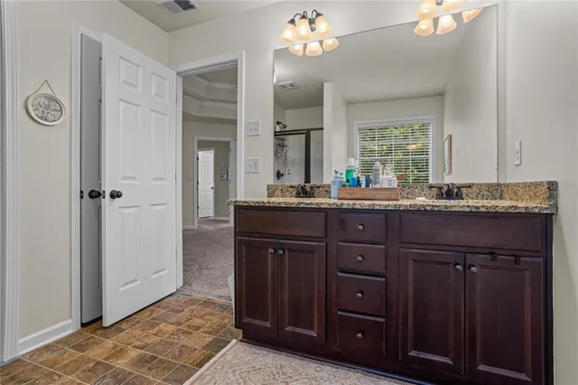 a bathroom with a granite countertop sink a mirror and a shower