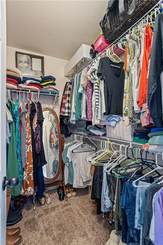 a view of walk in closet with clothes and shoes
