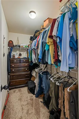 a view of walk in closet with clothes and shoes