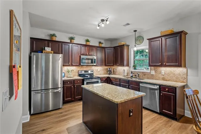 a kitchen with a refrigerator sink and wooden cabinets