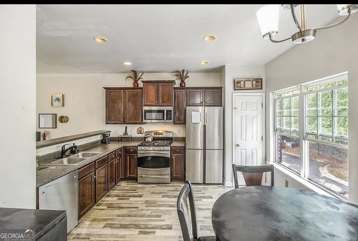 3669 Utoy Drive Southwest Atlanta, GA 30331 - Photo 11 of 22 a kitchen with stainless steel appliances granite countertop a stove top oven a sink dishwasher a refrigerator and white cabinets with wooden floor