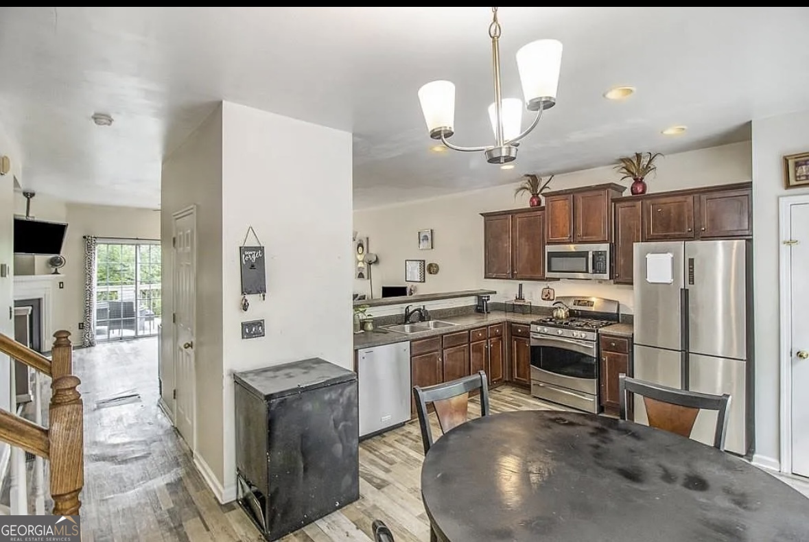 3669 Utoy Drive Southwest Atlanta, GA 30331 - Photo 10 of 22 a kitchen with a refrigerator a stove top oven a sink dishwasher and wooden cabinets