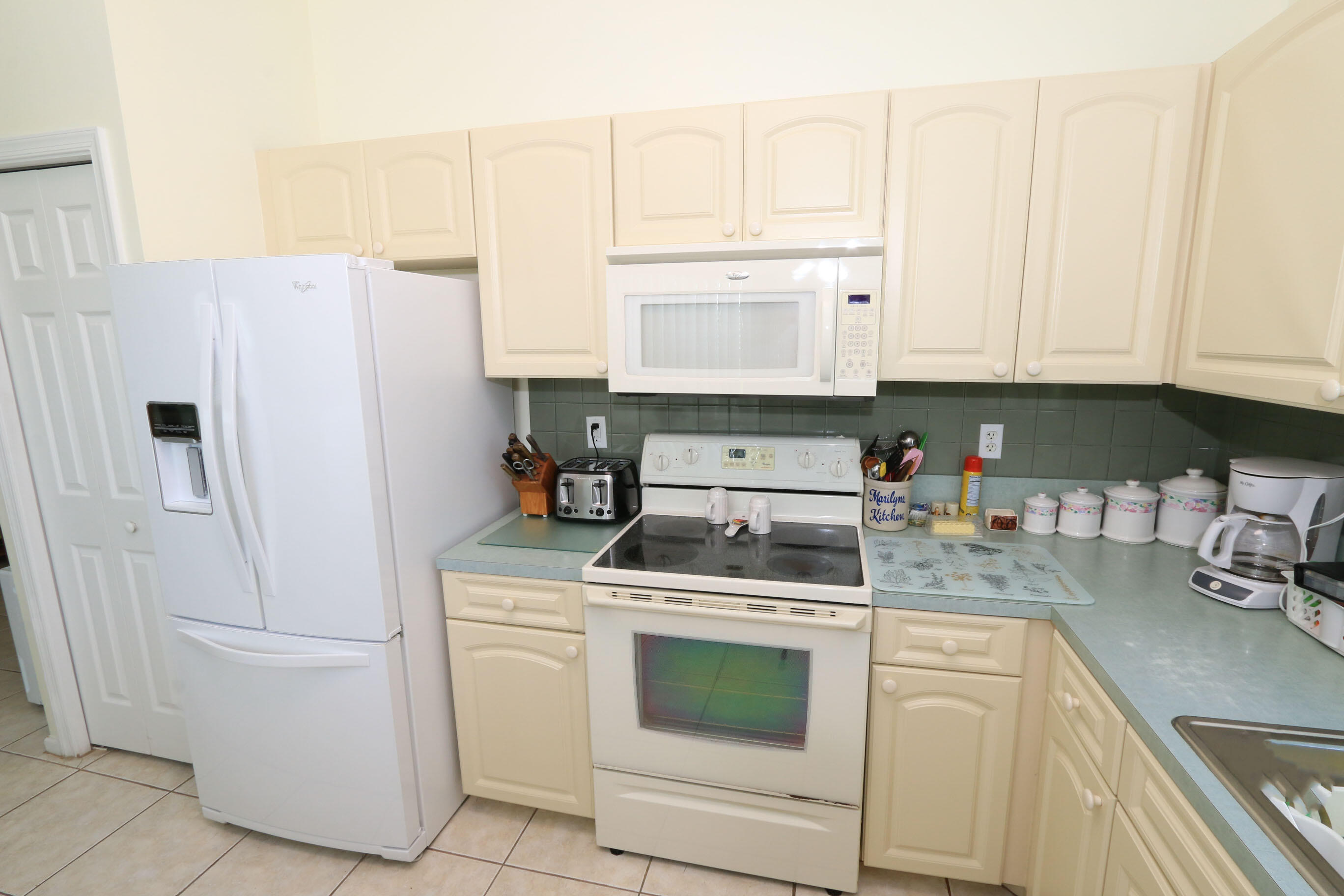 4350 Southwest 9th Way Okeechobee, FL 34974 - Photo 8 of 52 a kitchen with white cabinets and white appliances