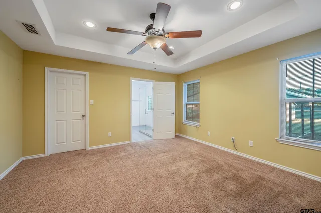 en empty room with ceiling fan and window