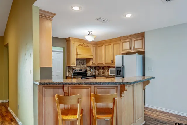 a kitchen with stainless steel appliances a sink and a refrigerator