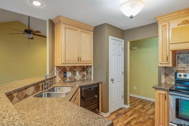 a bathroom with a granite countertop sink a mirror and shower