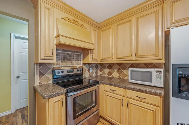 a kitchen with granite countertop cabinets stainless steel appliances and a counter space