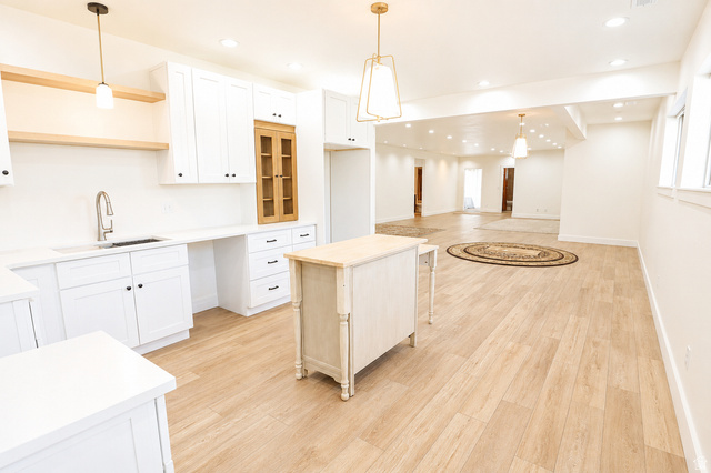 1055 North 1000 East Mapleton, UT 84664 - Photo 54 of 112 Contemporary kitchen featuring white cabinetry, light wood-finish flooring, a stainless steel sink with a gooseneck faucet, and an accent cabinet with glass panels
