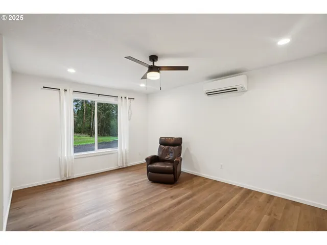 a living room with wooden floor and a ceiling fan