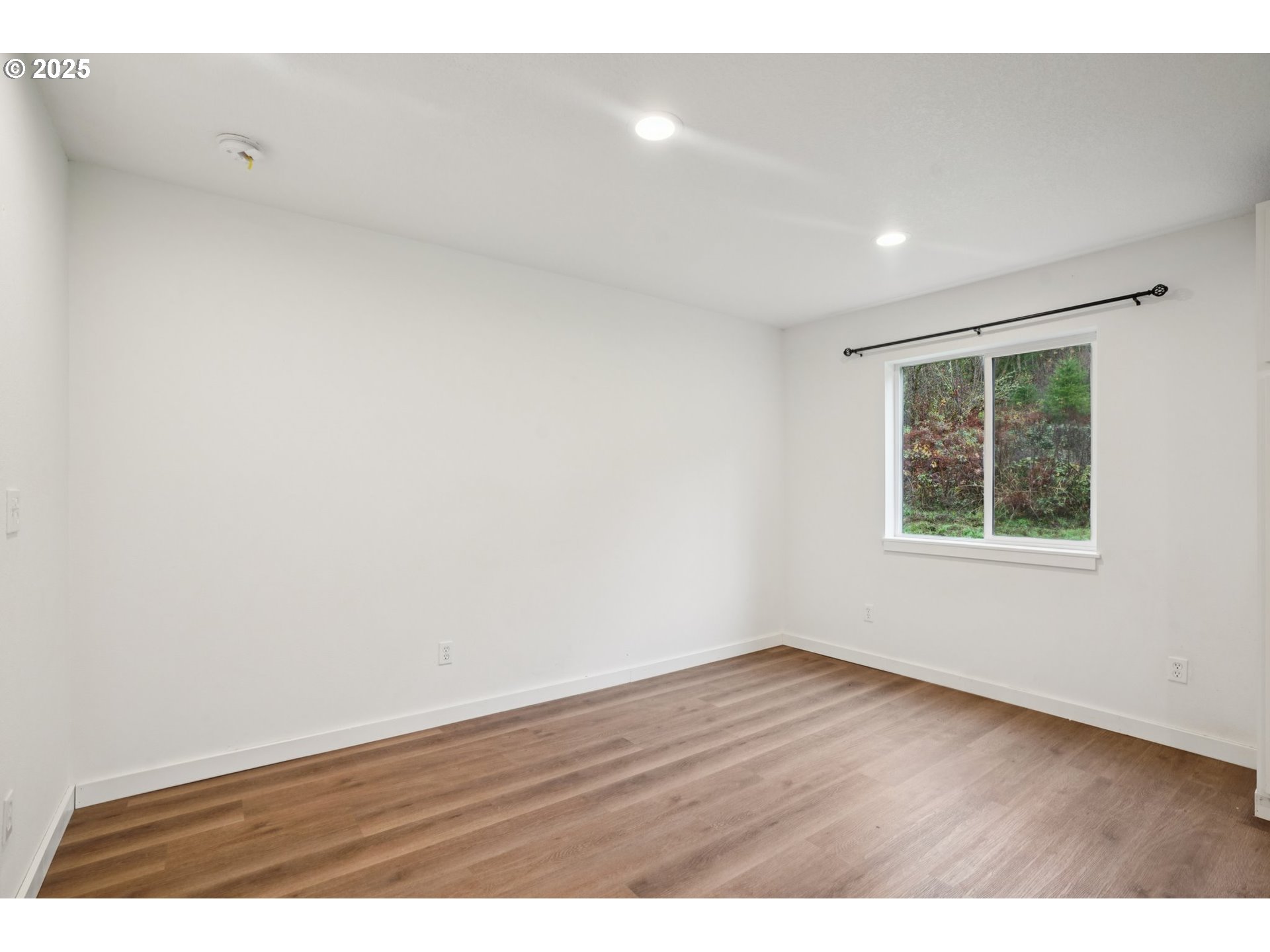 111 Finn Hall Road Woodland, WA 98674 - Photo 14 of 47 an empty room with wooden floor and windows
