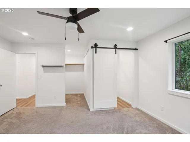 a big room with chandelier fan and windows
