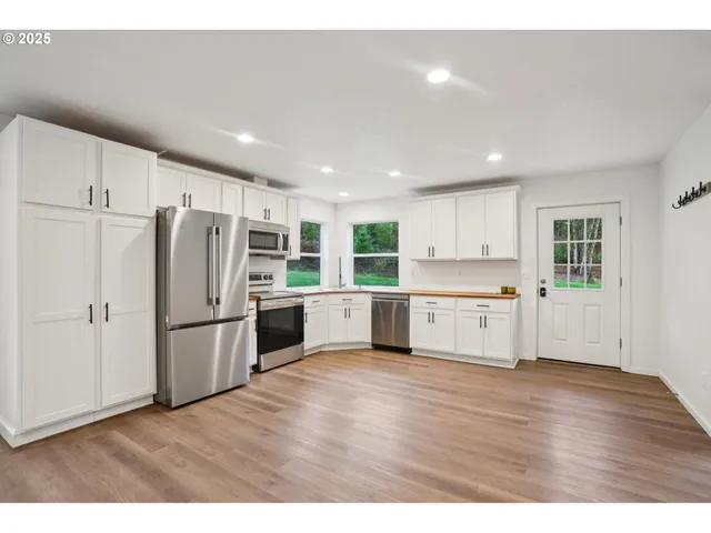 a kitchen with stainless steel appliances refrigerator sink and cabinets