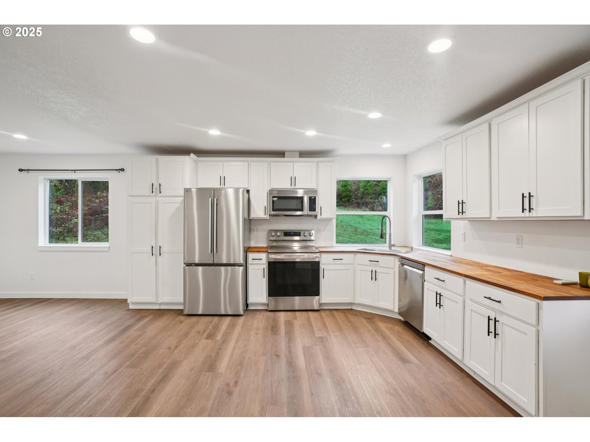 111 Finn Hall Road Woodland, WA 98674 - Photo 8 of 47 a kitchen with a refrigerator and white cabinets