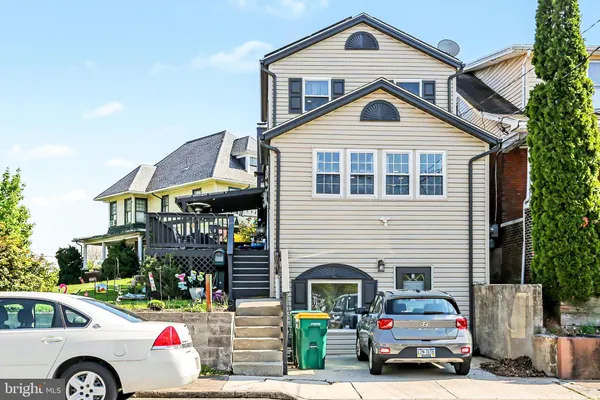 a front view of a house with cars parked