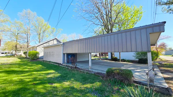 a view of a backyard with table and chairs and a large tree