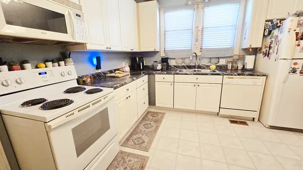 a kitchen with white cabinets appliances and a sink