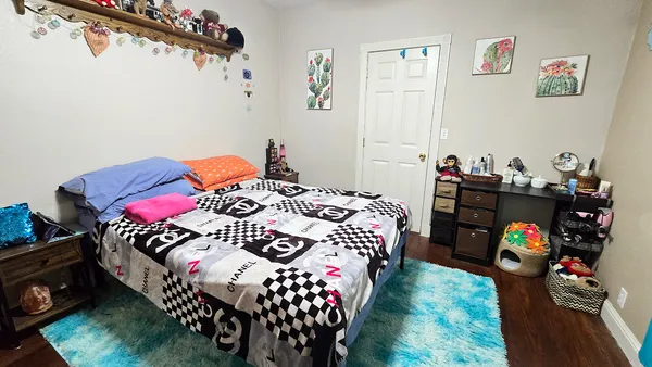 a bedroom with a bed a dresser and a baby crib