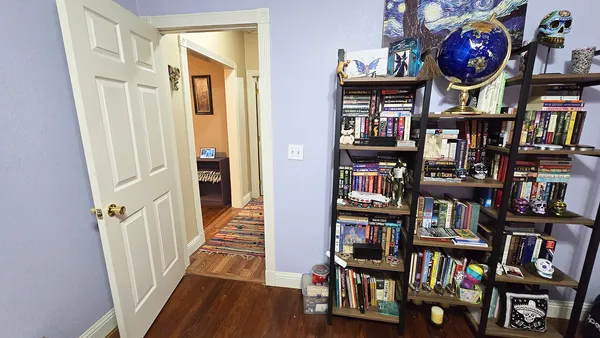 a view of an entryway with wooden floor and a book shelf