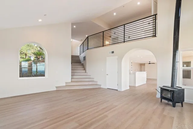 a living room with furniture kitchen view and a chandelier