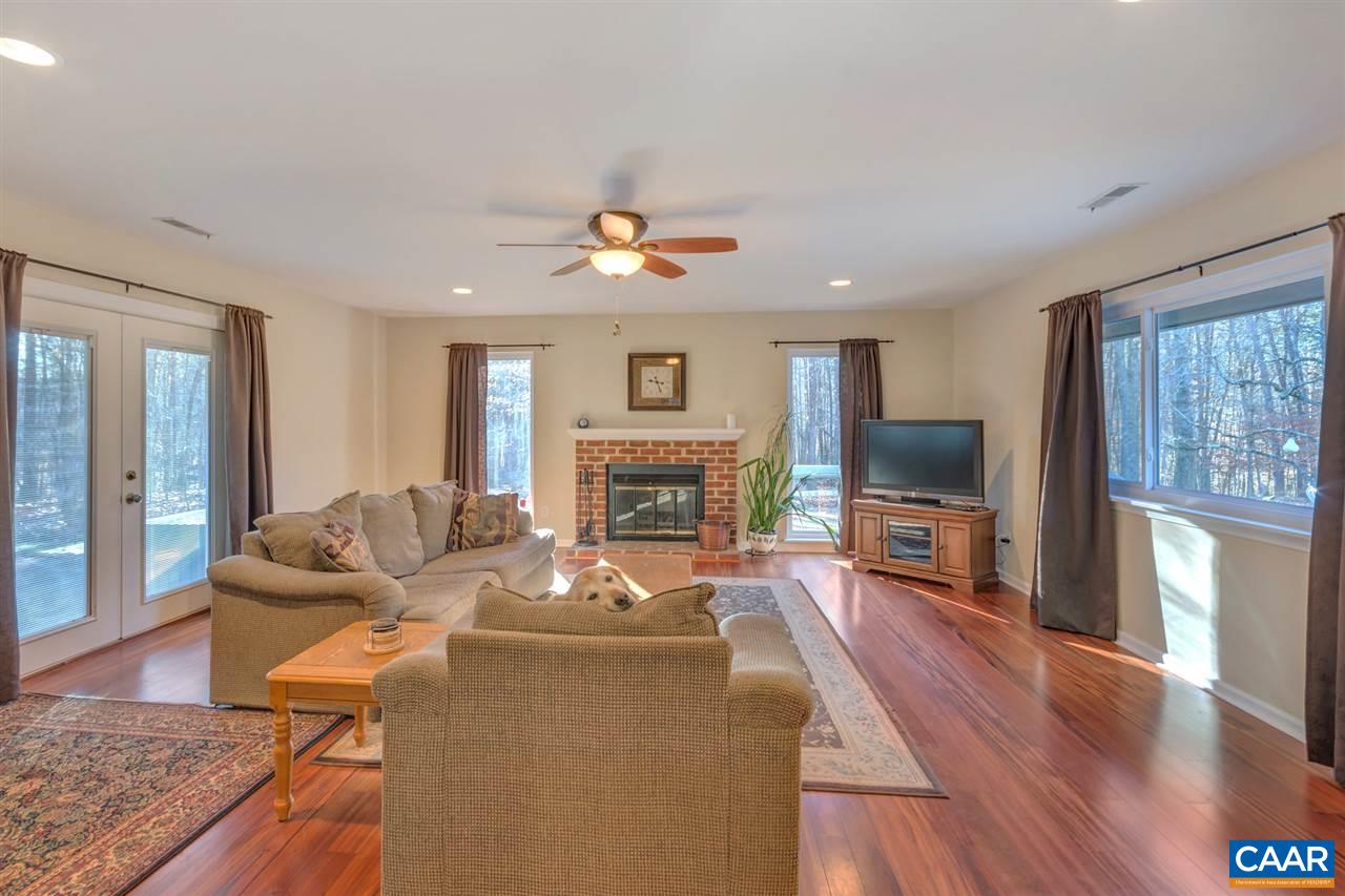 1065 Hunters Ridge Road Earlysville, VA 22936 - Photo 11 of 27 a living room with furniture a fireplace a flat screen tv and large windows