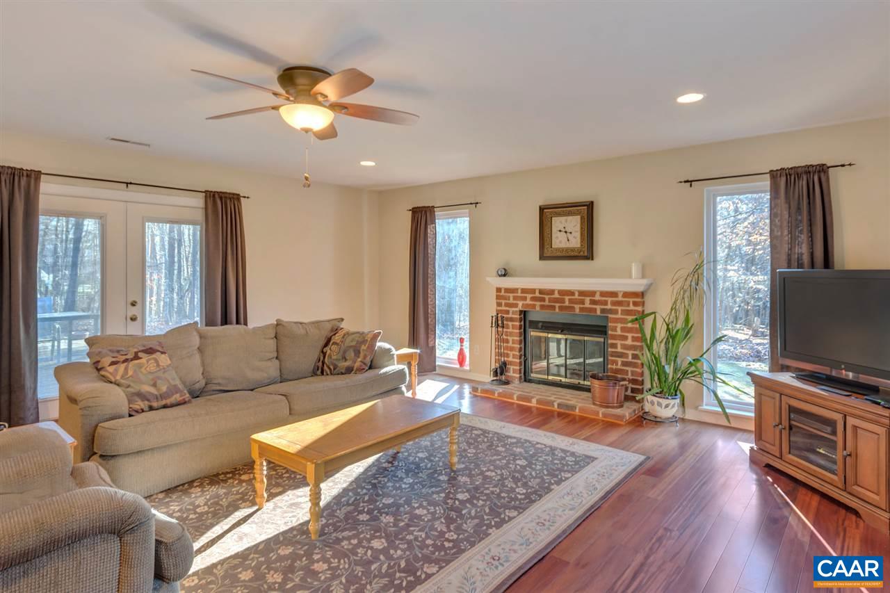 1065 Hunters Ridge Road Earlysville, VA 22936 - Photo 12 of 27 a living room with furniture a flat screen tv and a fireplace