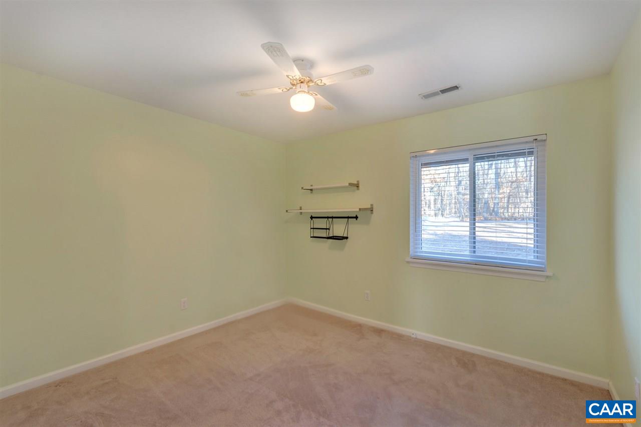 1065 Hunters Ridge Road Earlysville, VA 22936 - Photo 16 of 27 an empty room with a chandelier fan and windows